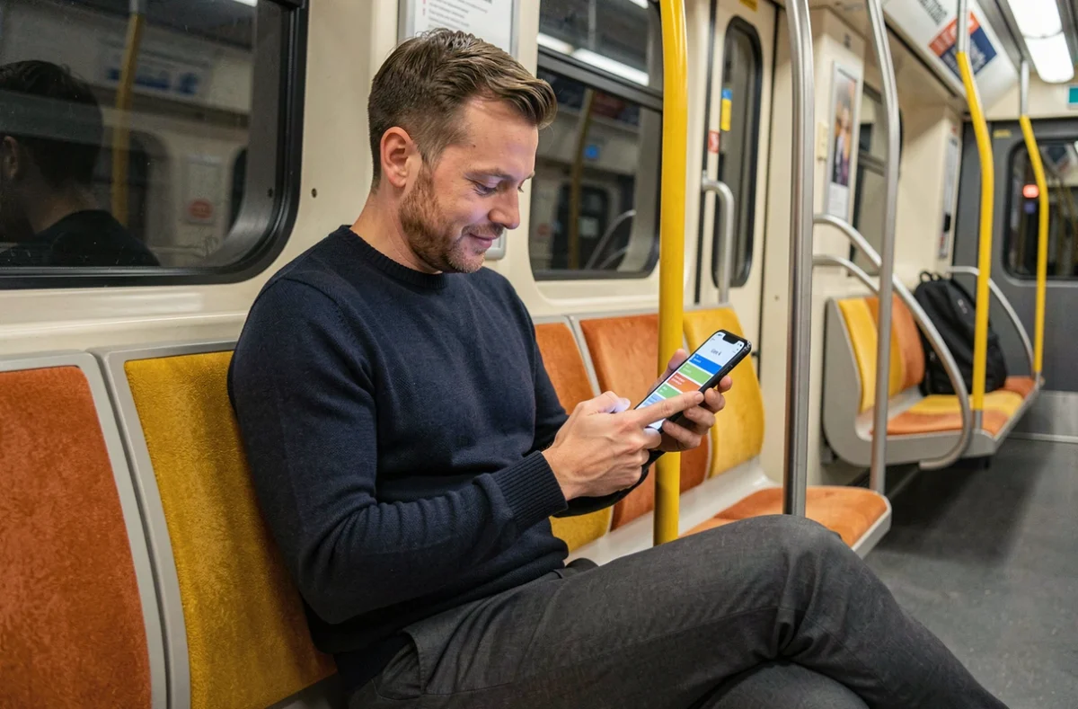 Homme utilisant une application de plan interactif de la ligne 4 du métro depuis l'intérieur d'une rame parisienne