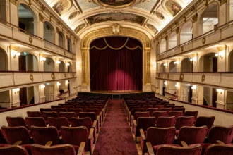 Vue panoramique de l'intérieur du théâtre Mogador montrant les rangées de fauteuils en velours rouge et l'architecture dorée de la salle